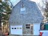 View of front of house featuring a gambrel roof and a garage