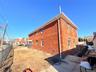 View of home's exterior with a fenced backyard and brick siding