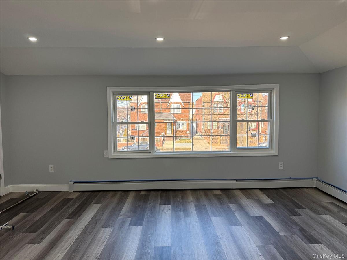 Empty room featuring healthy amount of natural light, recessed lighting, and dark wood-type flooring