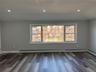 Empty room featuring healthy amount of natural light, recessed lighting, and dark wood-type flooring