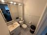 Half bath featuring vanity, a baseboard heating unit, tile walls, light tile patterned floors, and a wainscoted wall