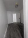 Empty room with dark wood-type flooring and baseboards