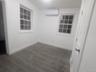 Spare room with a wall unit AC and dark wood-type flooring