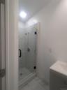 Full bathroom with vanity, light marble finish floors, and a marble finish shower