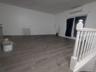 Unfurnished living room with dark wood-style flooring and a wall unit AC