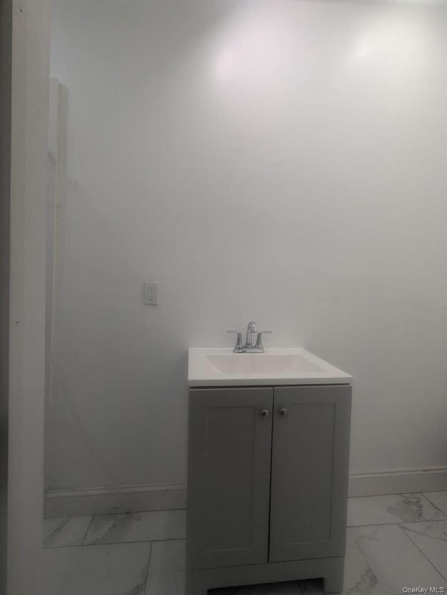 Bathroom with light marble finish flooring and vanity