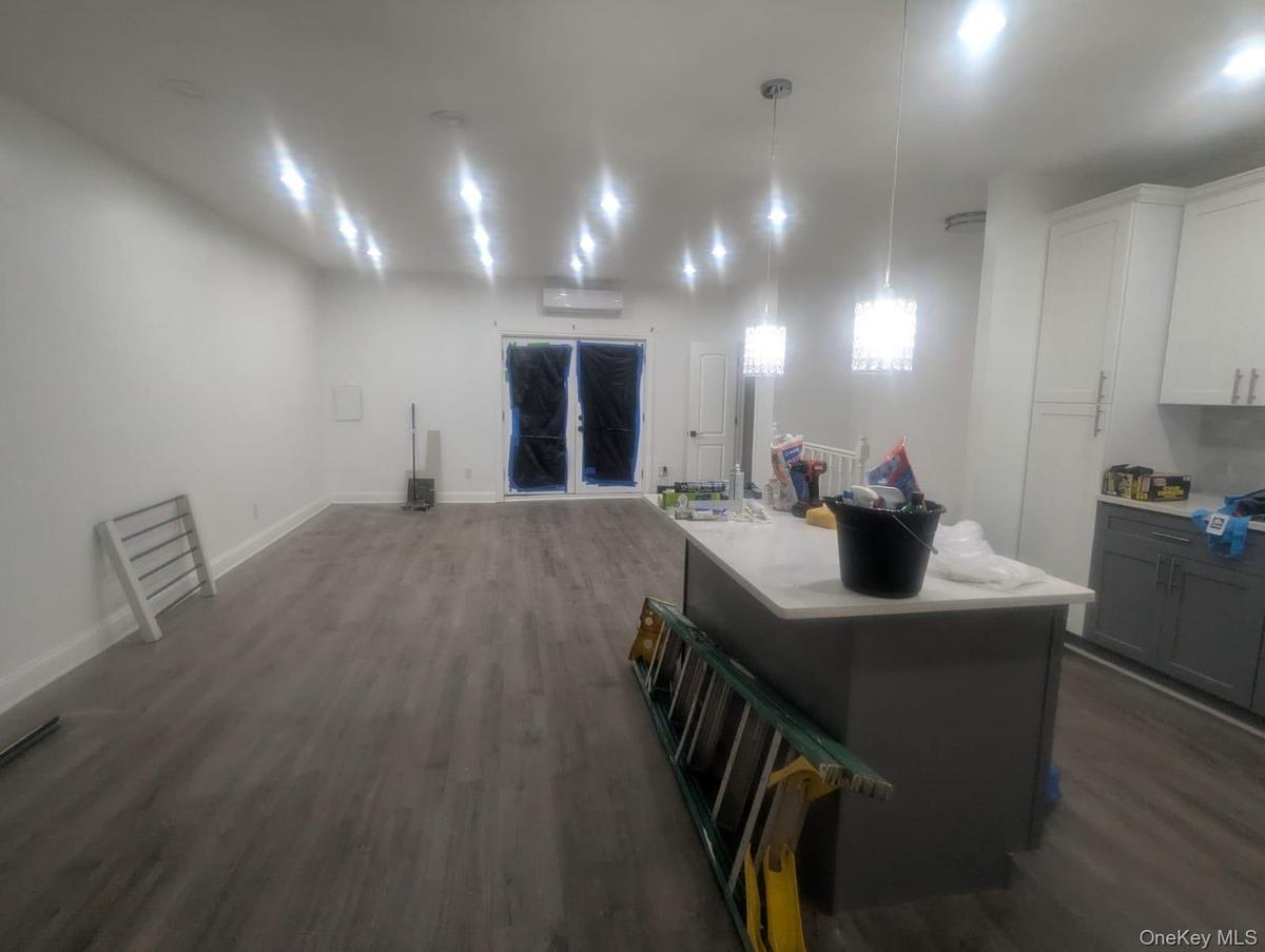 Kitchen featuring gray cabinetry, white cabinets, dark wood-style flooring, and hanging light fixtures