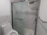 Full bath with a marble finish shower and tile walls