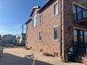 View of side of property featuring brick siding and a balcony