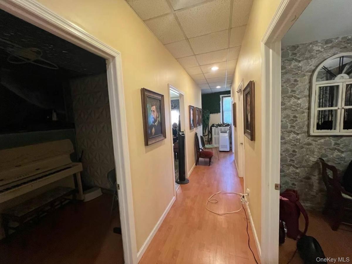 Hall featuring wood finished floors and a paneled ceiling