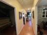 Hall featuring wood finished floors and a paneled ceiling