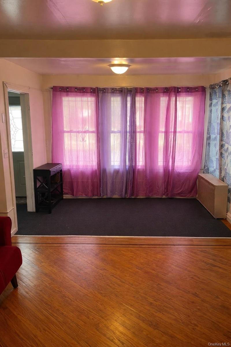 Unfurnished room with healthy amount of natural light and wood finished floors
