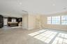 Unfurnished living room with crown molding, stairway, and recessed lighting