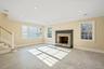 Unfurnished living room featuring stairway, a stone fireplace, crown molding, and recessed lighting