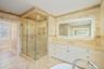 Bathroom with vanity, tile walls, a shower stall, light marble finish floors, and a soaking tub