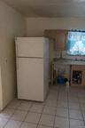 Kitchen with freestanding refrigerator, light countertops, and light tile patterned floors
