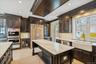 Kitchen featuring dark brown cabinetry, stainless steel appliances, wine cooler, backsplash, and recessed lighting