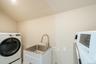 Washroom featuring washer / clothes dryer, lofted ceiling, and cabinet space
