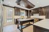 Kitchen with dark brown cabinetry, backsplash, crown molding, and recessed lighting