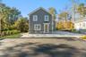 Rear view of property featuring a patio and stone siding