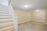 Below grade area featuring stairs and light marble finish floors