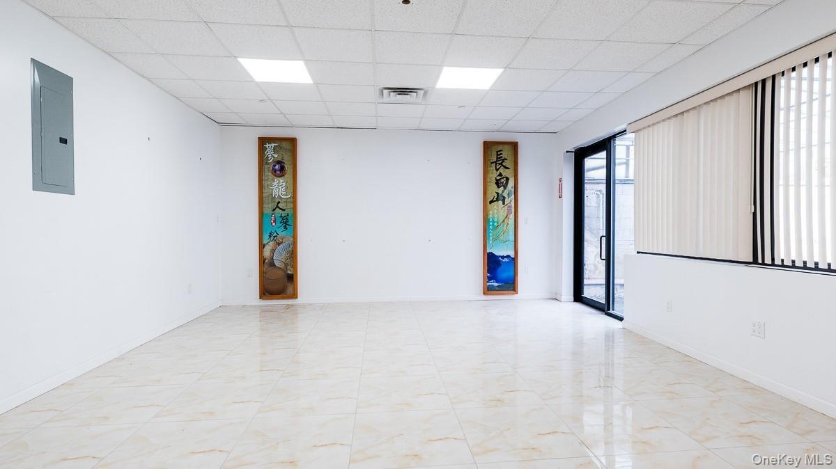 Spare room featuring a drop ceiling and electric panel