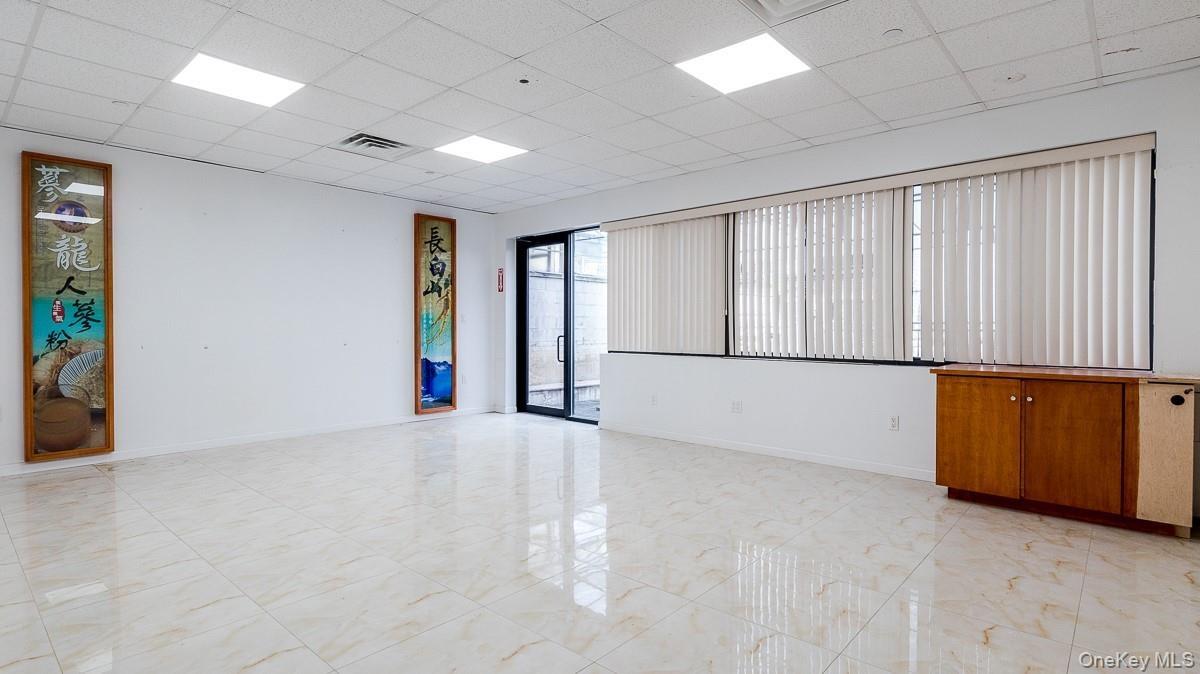 Spare room with a paneled ceiling and light marble finish flooring