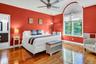 Bedroom featuring hardwood / wood-style flooring, ceiling fan, and ensuite bathroom