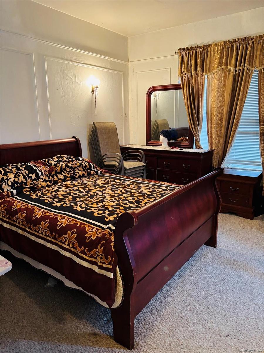 Bedroom featuring a decorative wall and carpet floors