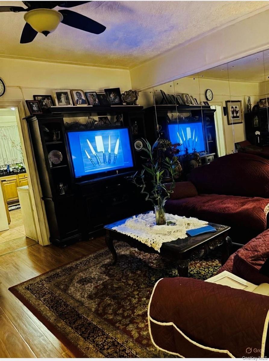 Living area with light wood-style floors, a textured ceiling, and ceiling fan