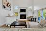 Tiled living area featuring a towering ceiling, a premium fireplace, and french doors