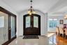 Entryway featuring a chandelier, french doors, light tile patterned floors, and lofted ceiling
