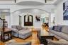 Living area with a chandelier, hardwood / wood-style floors, stairway, ornate columns, and a towering ceiling