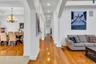 Hallway with light wood-style floors, ornate columns, arched walkways, recessed lighting, and a chandelier