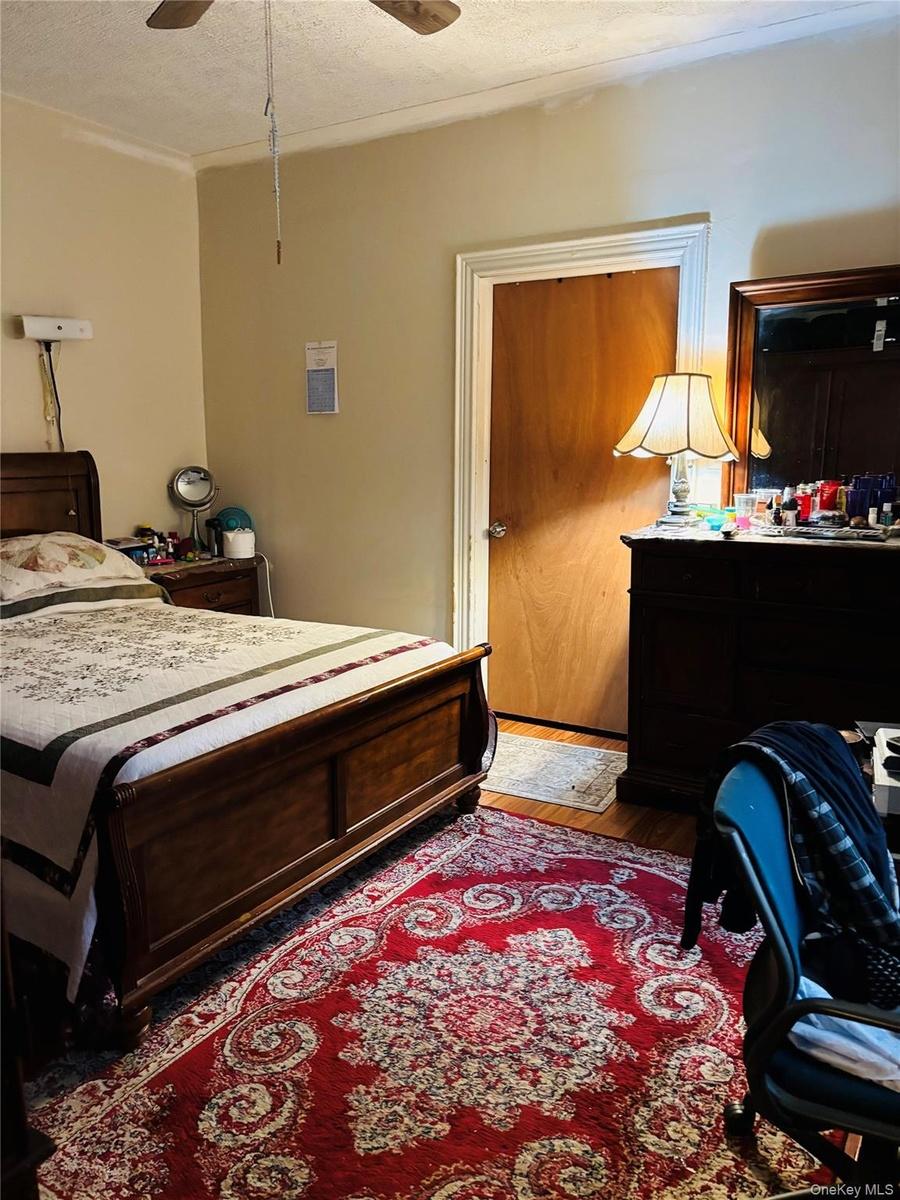 Bedroom with a textured ceiling and a ceiling fan