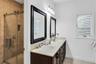 Full bathroom with double vanity, a shower stall, light tile patterned flooring, and healthy amount of natural light