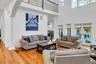 Living area featuring hardwood / wood-style floors, ornate columns, arched walkways, and a high ceiling