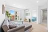 Living area featuring light wood-style floors, recessed lighting, and an AC wall unit