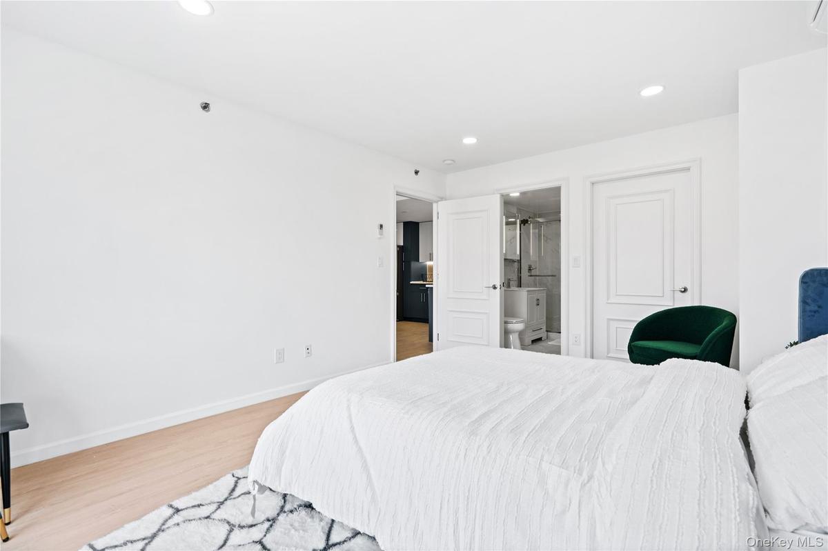 Bedroom featuring light wood-type flooring, recessed lighting, and connected bathroom