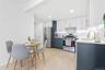 Kitchen featuring white cabinetry, stainless steel appliances, light wood-style floors, light stone counters, and decorative backsplash