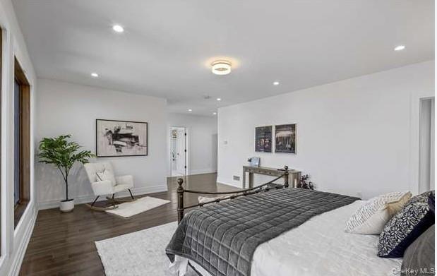 Bedroom with dark wood finished floors and recessed lighting