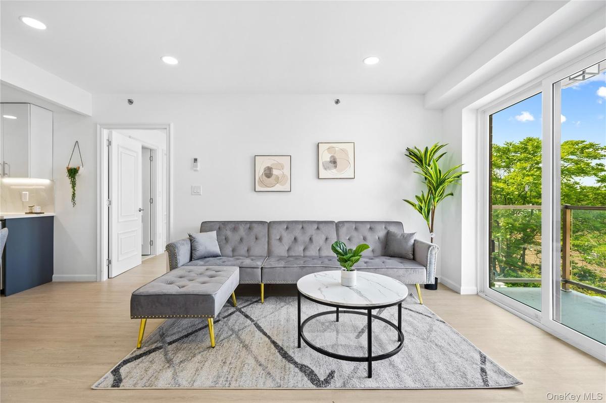 Living room with light wood-style flooring and recessed lighting