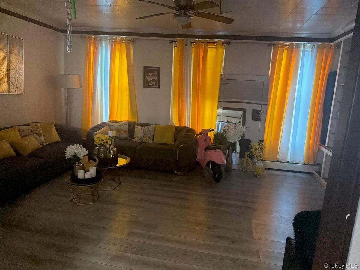 Living area with wood finished floors and a ceiling fan