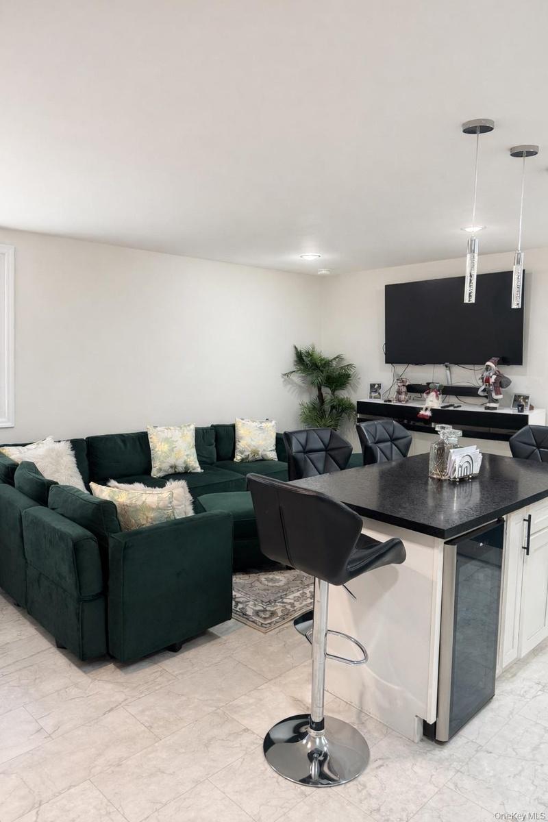 Living room featuring beverage cooler and light marble finish floors