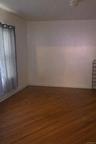 Unfurnished room with baseboards and dark wood-type flooring