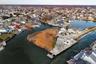 Aerial view of property and surrounding area with a nearby body of water and nearby suburban area