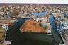 Aerial view of property's location featuring a nearby body of water and nearby suburban area