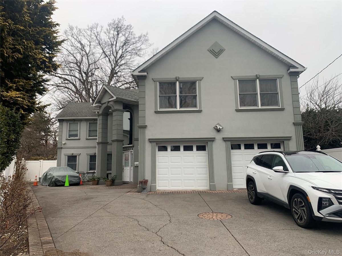 Traditional-style house featuring stucco siding, concrete driveway, an attached garage, and a shingled roof