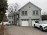 Traditional-style house featuring stucco siding, concrete driveway, an attached garage, and a shingled roof