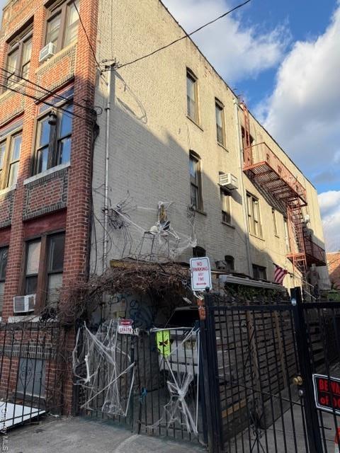 View of building exterior featuring a wall mounted AC
